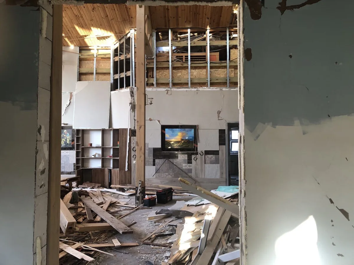 Zerstörung, wo einst Menschen gewohnt haben: Der Krieg zwingt sie, ihr Zuhause zu verlassen. Ein Blick in ein Wohnzimmer, das von Trümmern übersät ist.